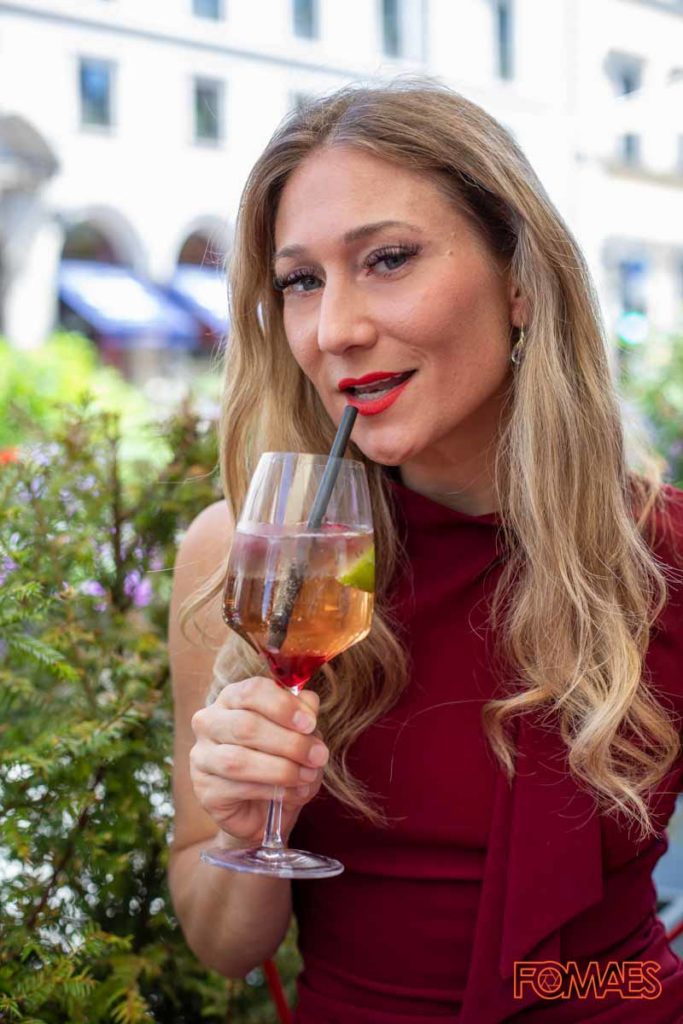 Frau in einer Straßenbar mit Trinkglas in der Hand