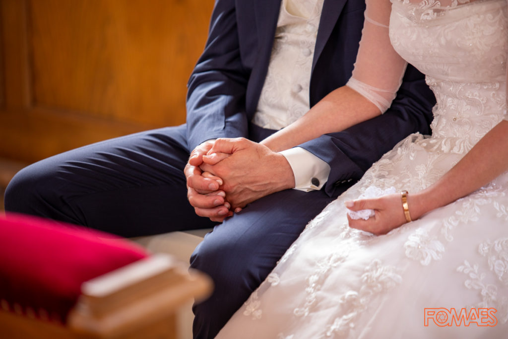 Der Bräutigam hält die Hand der Braut in der Kirche